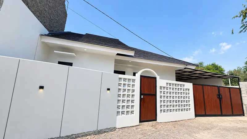 Fasad putih dengan pagar roster dan pintu kayu